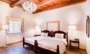a bedroom with two beds and a chandelier at The Dominican in Prague