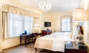 a bedroom with a bed and a desk and a chandelier at The Dominican in Prague