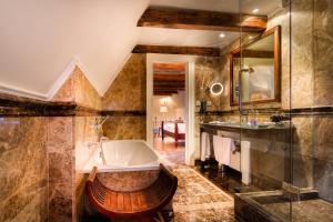 a bathroom with a tub and a sink at The Dominican in Prague