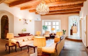 a living room filled with furniture and a chandelier at The Dominican in Prague