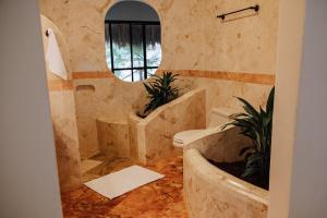 a bathroom with a tub and a toilet and a mirror at Villas Kaàn in Puerto Morelos +50 photos