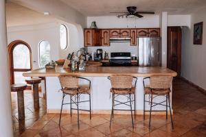 a kitchen with a counter with bar stools at Villas Kaàn in Puerto Morelos