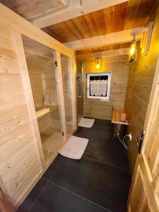 a small bathroom with a shower in a wooden house at Baita Alpenrose in Ugovizza +56 photos