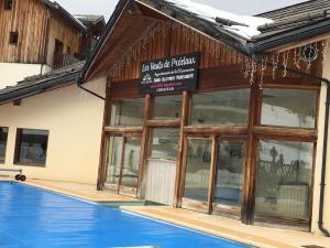 a building with a sign on the side of a swimming pool at Les orres 1800 appartement 4 personnes au pied des pistes in Les Orres +2 photos
