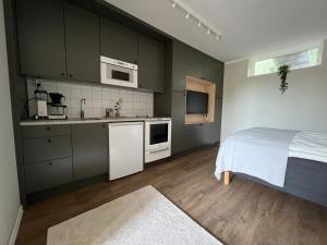 a bedroom with a bed and a kitchen with a sink at Gäststuga in Alingsås