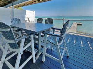 a table and chairs on a deck with the ocean at Put-in-Bay Waterfront Condo #105 in Put-in-Bay