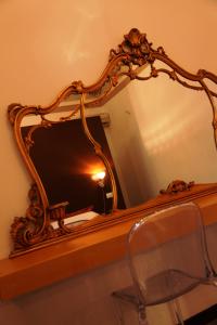 an ornate mirror on a table with a chair at B&B Casa Ruffino in Balestrate