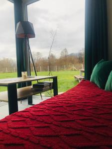 a bedroom with a bed and a table and a window at TinyHouses & Garden in Oravská Poruba