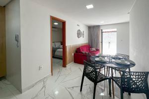 a dining room with a table and chairs and a living room at Aconchegante Térreo Bessa 4 pessoas 200m da Praia in Nossa Senhora do Livramento