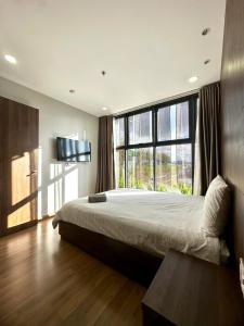 a bedroom with a large bed and a large window at Reply 1996 Apartment in DaLat Center in Da Lat