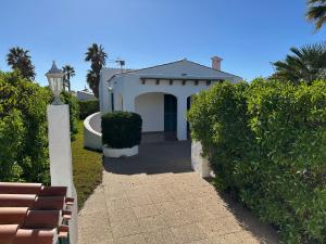 a white house with a pathway leading to it at Villa Isabel in Cala'n Bosch