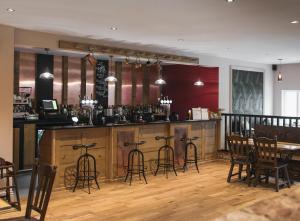 a bar in a restaurant with bar stools at Healing Manor Hotel in Grimsby