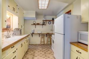 a kitchen with a white refrigerator and a sink at Chatterton's Cottage in Wawona