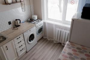 a kitchen with a stove and a washing machine at Махаббат in Petropavlovsk