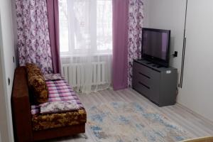 a living room with a chair and a tv at Махаббат in Petropavlovsk