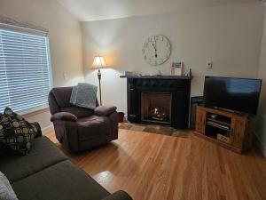un salon avec une cheminée et une télévision dans l'établissement Charming, Private Cottage in Myrtle Creek, à Myrtle Creek