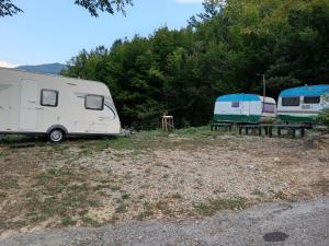 two rvs parked in a field next to trees at Wild Camping Albareto in Albareto