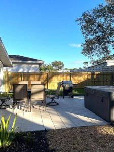 un patio avec des chaises, une table et un grill dans l'établissement Fully Fenced With Hot tub near Siesta Key Bridge, à Sarasota 12 autres photos