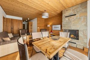 a dining room with a table and a fireplace at Ski-In Jasna Otupne Apartment & Lodge in Demanovska Dolina