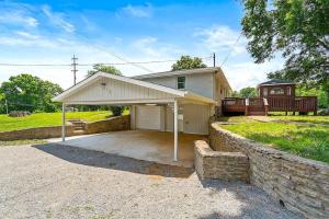 una casa con garaje y pared de piedra en New Listing Paradise Found Hot tub Pool More, en Nashville