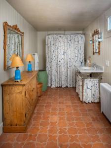 a bathroom with a shower and a sink and a table at Willow Vale - Stunningly Designed Historical Icon with Hot Tub in Pine Plains