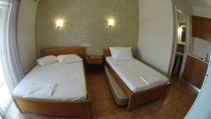 a small room with two beds and a mirror at Villa Marina Neoi Poroi in Nei Poroi