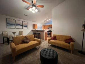 a living room with two chairs and a ceiling fan at Paradise Skies in Albuquerque