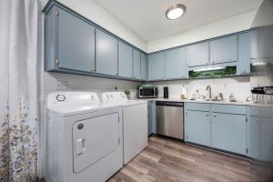 a kitchen with blue cabinets and a white dishwasher at Peaceful APT by Lakebottom w Arcade 8mi Ft Moore in Columbus
