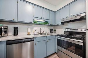 a kitchen with blue cabinets and stainless steel appliances at Peaceful APT by Lakebottom w Arcade 8mi Ft Moore in Columbus
