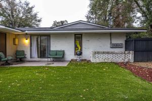 a small white house with green chairs in a yard at Peaceful APT by Lakebottom w Arcade 8mi Ft Moore in Columbus
