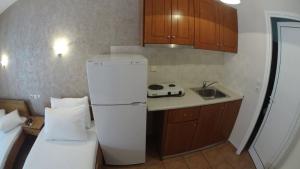 a small kitchen with a refrigerator and a sink at Villa Marina Neoi Poroi in Nei Poroi