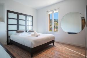 Un dormitorio con una cama grande y un espejo. en Bas de villa plus piscine Vue époustouflante, en Villefranche-sur-Mer 43 fotos más