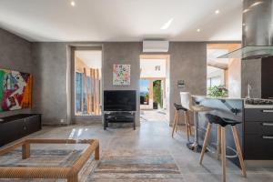 cocina con sala de estar con mesa y fogones en Bas de villa plus piscine Vue époustouflante, en Villefranche-sur-Mer