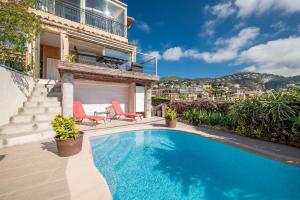 una piscina con dos sillas y una casa en Bas de villa plus piscine Vue époustouflante, en Villefranche-sur-Mer