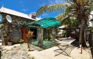 ein Haus mit einer Hängematte und einer Palme in der Unterkunft Rustic Balinese Villa in Grand Baie