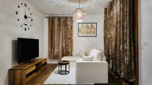 ランジスにあるTrès bel appartement ambiance cosyのリビングルーム(テレビ、白いソファ付)