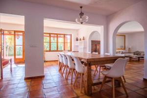 una sala da pranzo con tavolo e sedie in legno di Casa Roja Ibiza a Illes Balears Altre 23 foto