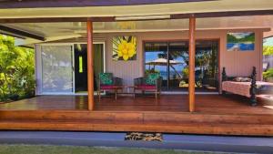 uma casa com um deque de madeira com vista para o oceano em MOOREA - Fare Nihei em Maharepa