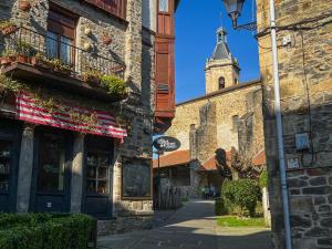 a street with a building with a clock tower at Golliber Baserrie in Areatza