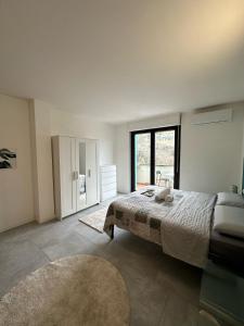 a bedroom with a large bed and a large window at Il Guernico appartamenti in Volterra