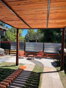 a group of benches sitting under a wooden pergola at Estudio Relax Las Sierras in El Volcán