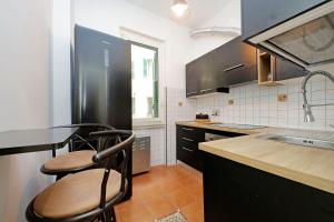 a kitchen with a black refrigerator and a sink at Stella Polare Sensorial Home in Lido di Ostia