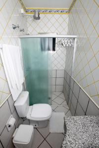 y baño con aseo y ducha acristalada. en Costabela Apart Hotel e Pousada, en Ilhabela