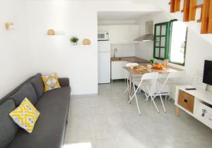 a living room and kitchen with a couch and a table at Bungalow Capri Maspalomas in San Bartolomé