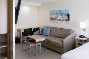 a hotel room with a couch and a table and chairs at Homewood Suites by Hilton Tulsa South Medical District in Tulsa