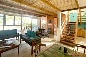 ein Wohnzimmer mit Sofa und Tisch in der Unterkunft LC Casas de Praia Jardim dos Guajirus in Tamandaré