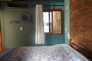 ein Schlafzimmer mit einem Bett und einem Fenster in der Unterkunft LC Casas de Praia Jardim dos Guajirus in Tamandaré + 57 Fotos