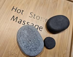 two rocks on a wooden table with the words hot stones massage at Wildblick Appartment Hof Grindelborn in Mürlenbach +26 photos