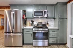 a kitchen with green cabinets and a stainless steel refrigerator at The Little Creek Cabin in Wawona +14 photos