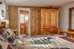 a bedroom with a bed and a wooden wall at The Little Creek Cabin in Wawona